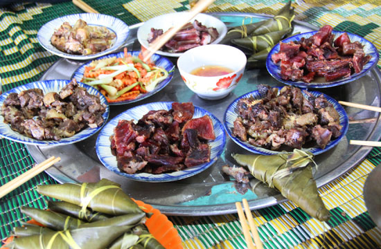 Một bàn ăn của người Cơ tu với cá nướng, rau rừng, thịt nướng, cơm lam... cùng các loại rượu đặc trưng.